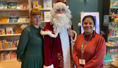 Three library staff, one dressed as Santa, at Williams Landing Library Lounge