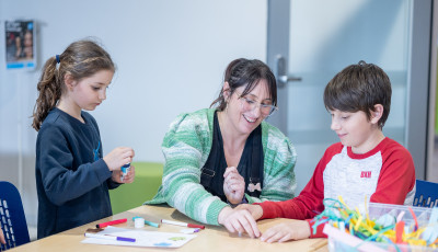 2 children and an adult completing a craft activity at the library.