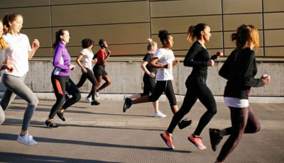 a group of people in fitness clothing are running down a road
