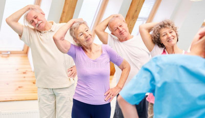 a group of older people are standing with their hand on their head pulling it to the side