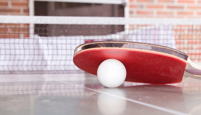 A table tennis bat rests on a ball
