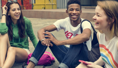 teens sitting down smiling