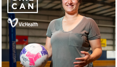 a woman wearing a grey t shirt holds a netball