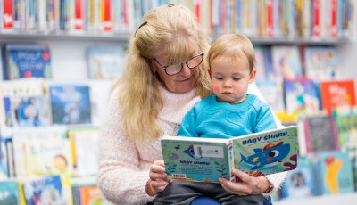 A child and adult reading together.