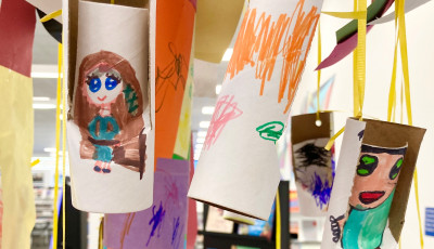 Kids craft of decorated paper rolls hanging in the library