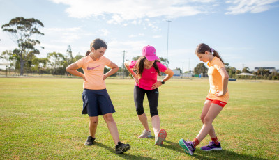 Women and children stretching on grass