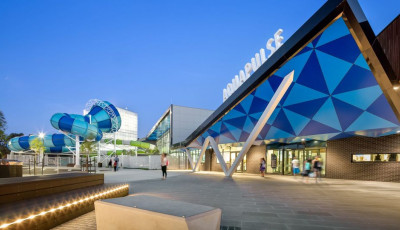 a blue building with an enclosed blue slide beside it that twists around 360 degrees 