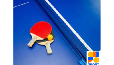 Blue table tennis table and net with a red and black bat resting and a yellow table tennis ball