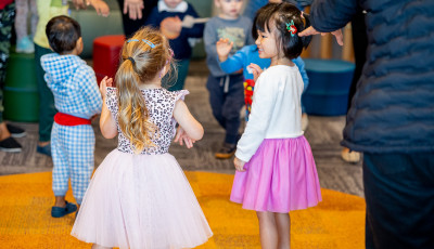 Children standing and smiling in the library.