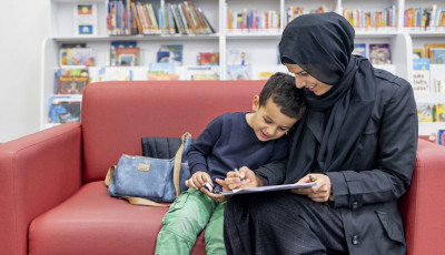 Mother and child sitting on a couch doing a craft activity together