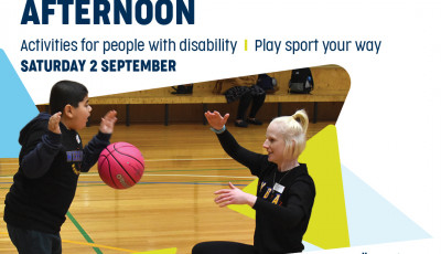 a boy bounces a ball facing an adult kneeling down demonstrating the skill