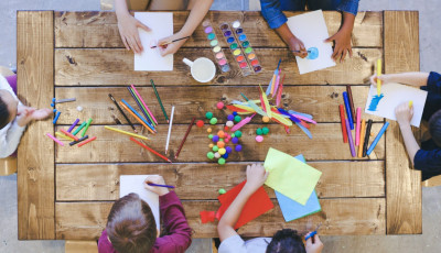 looking down onto a table where kids are doing craft activities