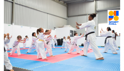 a group of people wearing karate uniforms are facing an instructor
