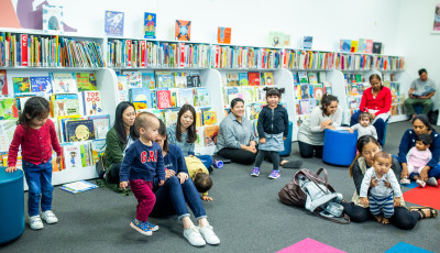 Children and parents sitting on the floor in the library.
