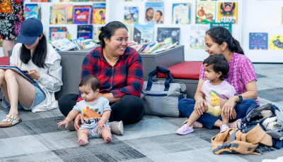 Parents and children sitting together in the library.