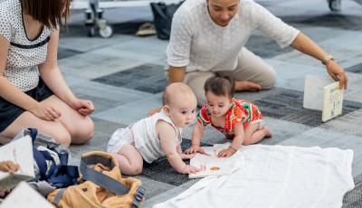 Mothers and babies playing on the floor in the library.