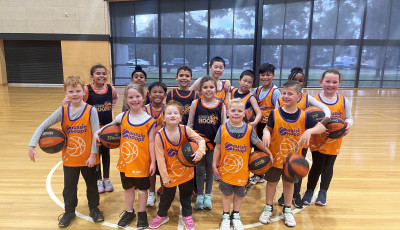 a group of kids wearing yellow basketball vests are smiling at the camera