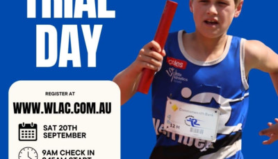 A boy wearing a blue top and carrying a baton is running towards the camera