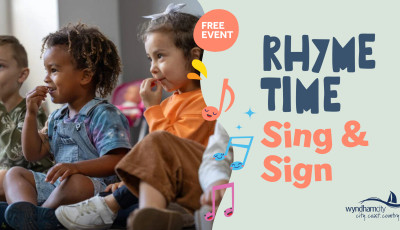 Three young children sit on the floor and practise Auslan signs.