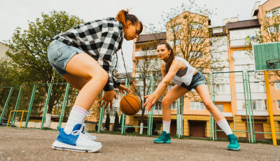 two girls playing basketball outside