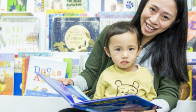 Mother reads to child with a picture book