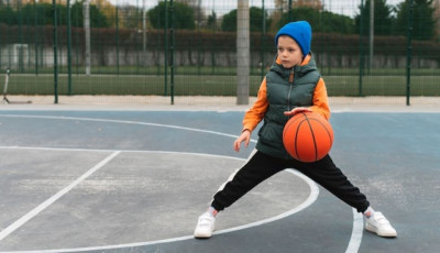 a boy is bouncing a basketball