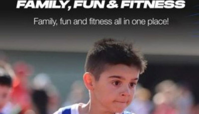 a boy wearing a blue running vest is running on a track