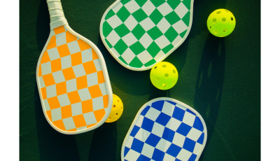 three brightly coloured bats: orange, blue and green and two yellow balls